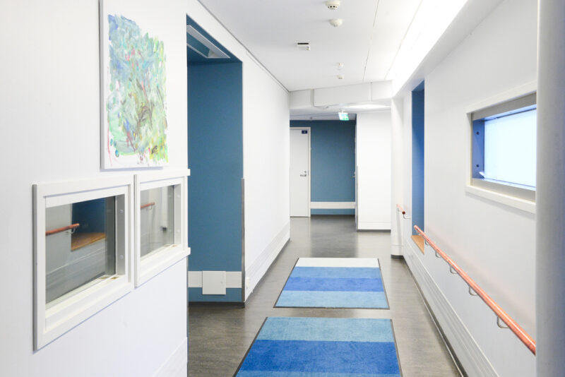 Yksikössä on sinisen ja valkoisen sävyinen iso käytävä, josta ovia yksikön muihin tiloihin ja asukkaiden koteihin.